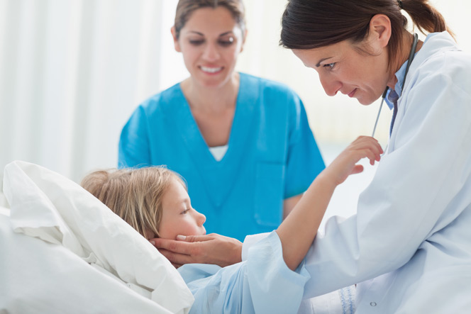 child patient in bed with Dr and nurse attending bedside